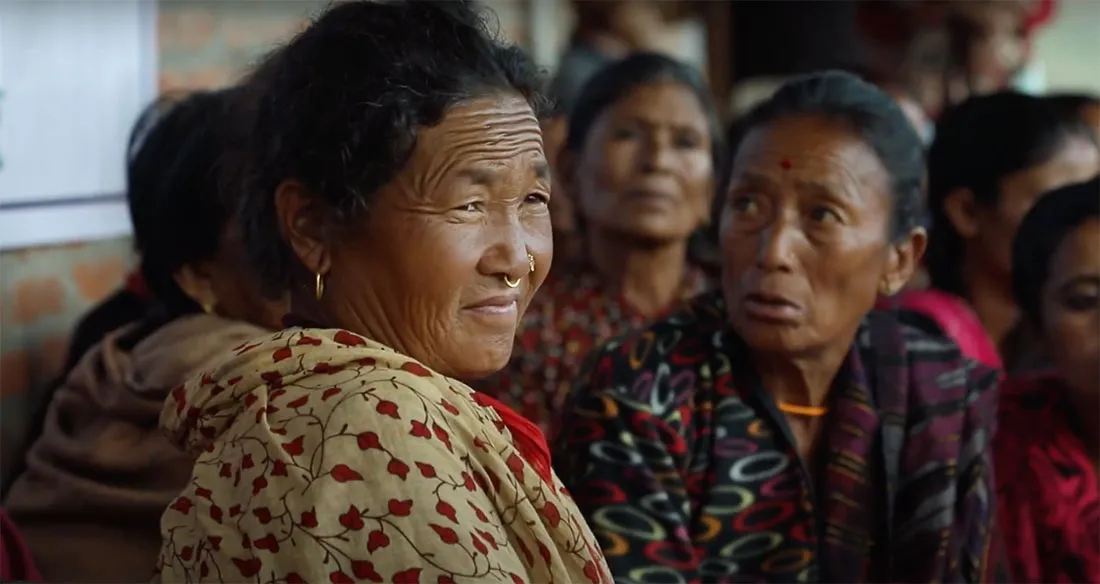 A middle-aged woman in a group of Nepali women.