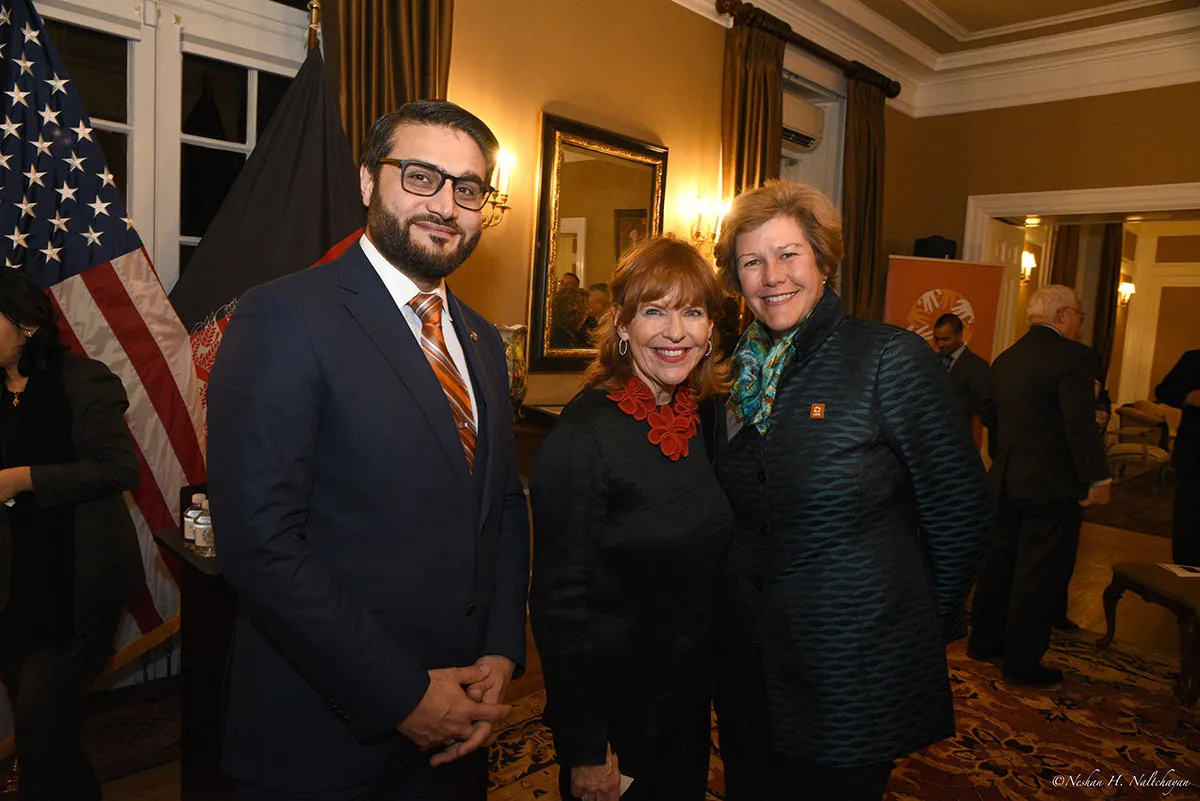 A woman in black dress stands between Ambassador Hamdullah Mohib and a woman in a dark green suit