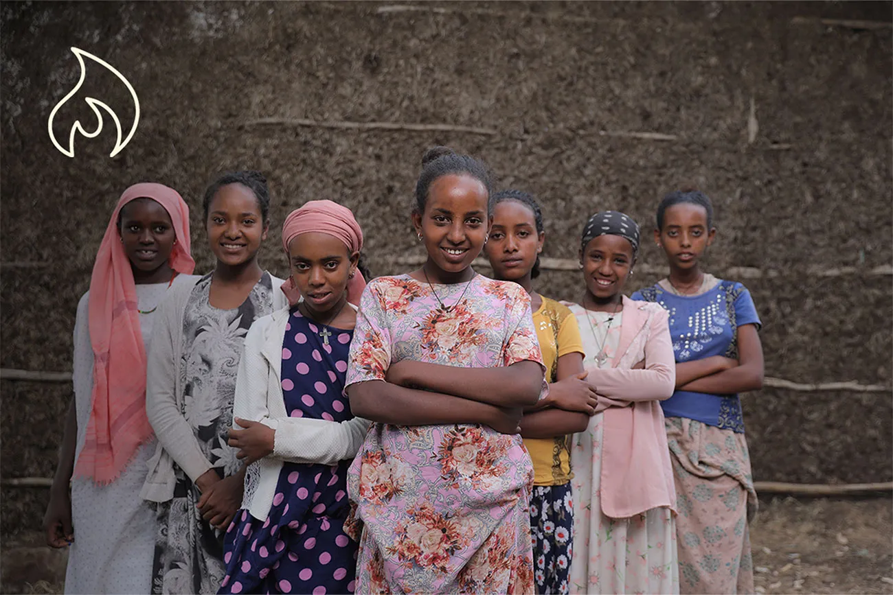 A group of girls smile at the camera while crossing their arms.