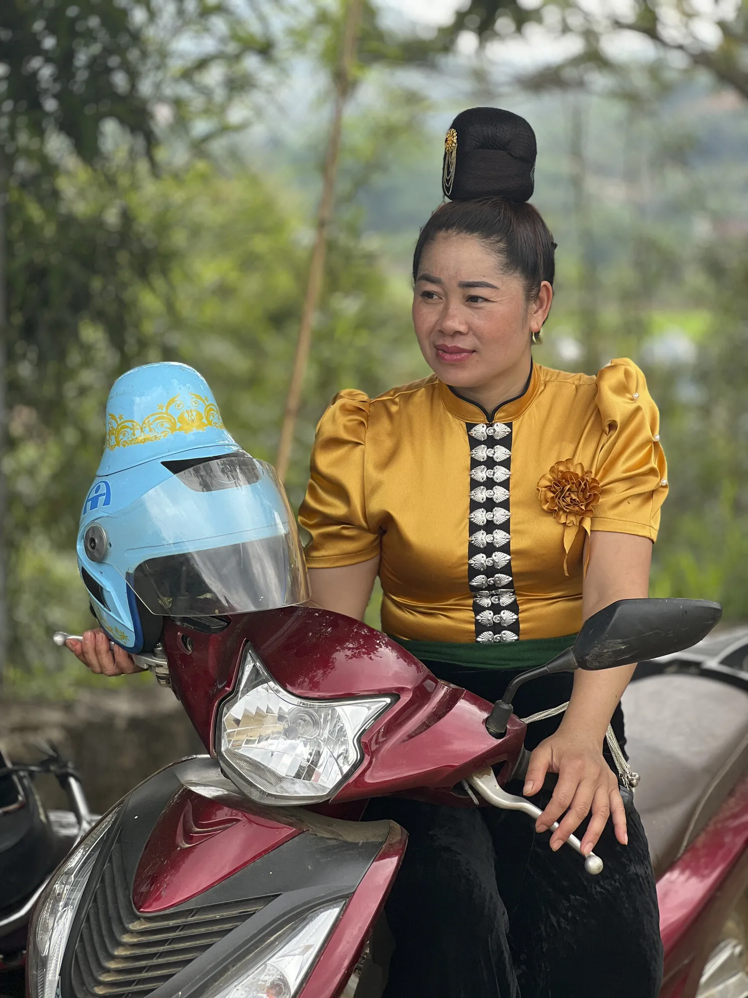 Woman in traditional dress sitting on a motorcycle