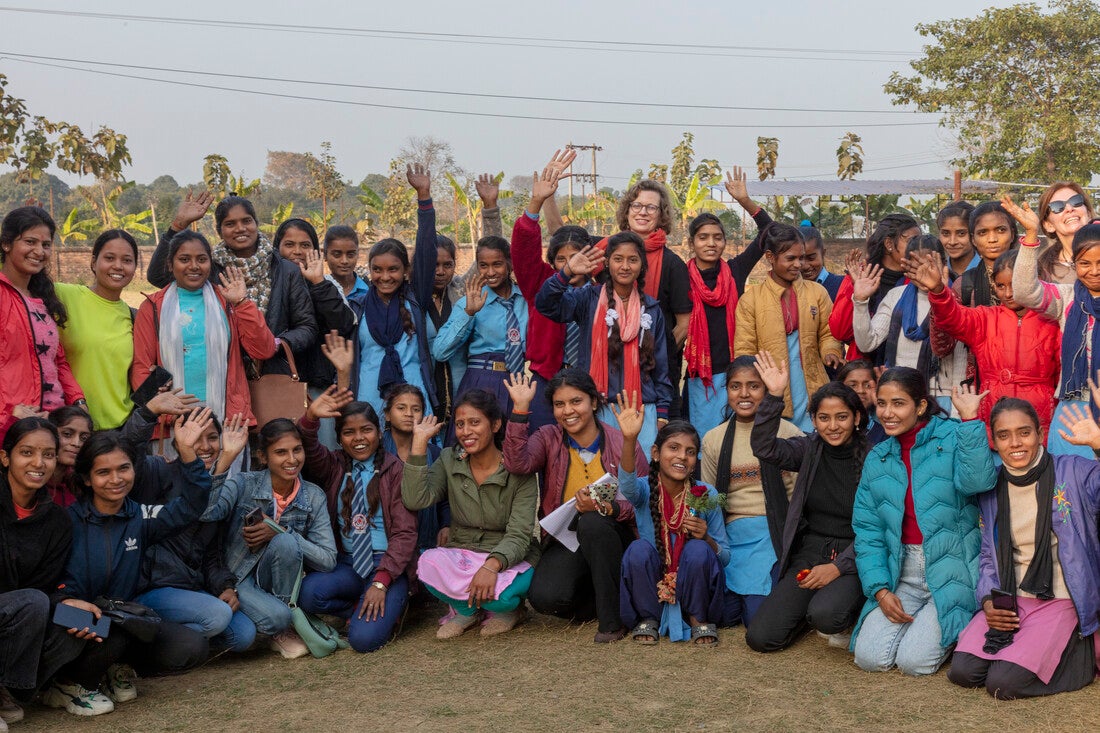 CARE CEO Michelle Nunn stands and waves among a large group of Nepali women.