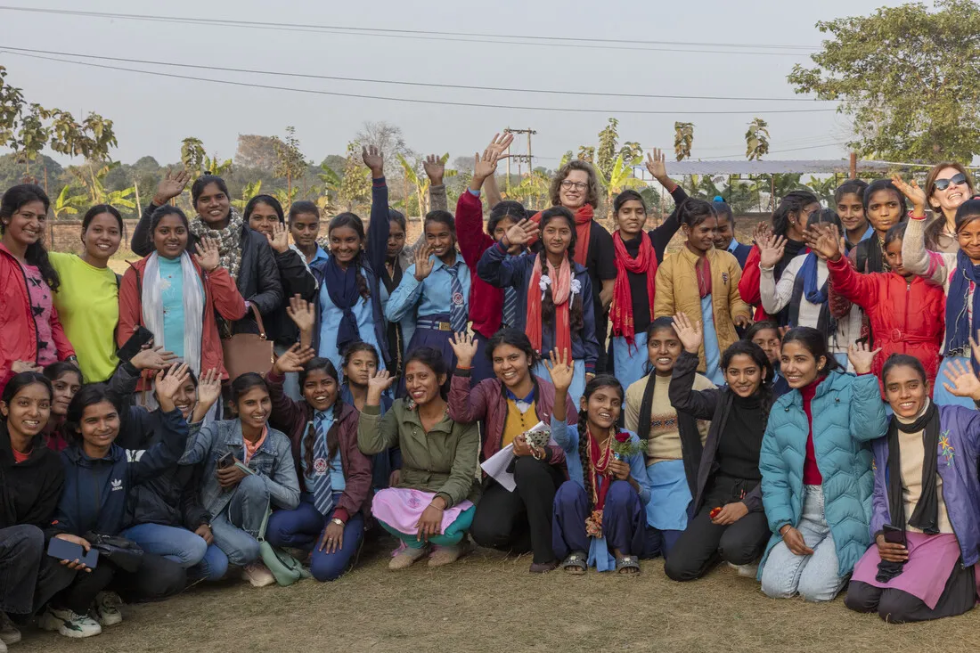 CARE CEO Michelle Nunn stands and waves among a large group of Nepali women.