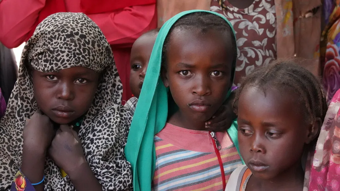 Three young children huddle together