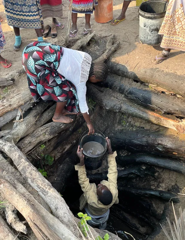 Two women, CARE project participants, are seen fetching water from a deep well in a drought-affected region in Mozambique.