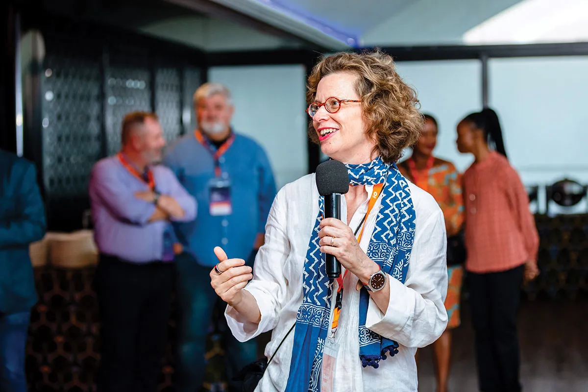 CARE CEO Michelle Nunn smiles while holding a mic.