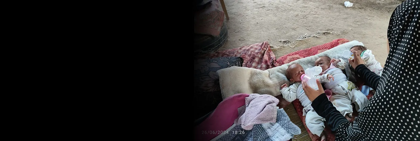 A mother in Gaza looks down at her three newborn triplets.