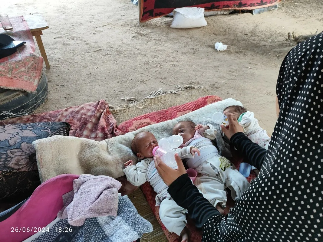 A mother in Gaza looks down at her three newborn triplets.