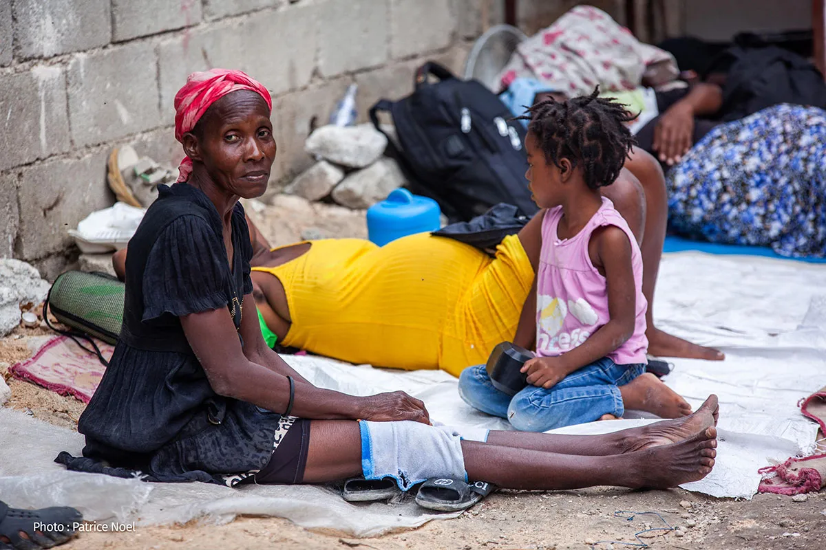 A group of displaced people in a makeshift shelter.