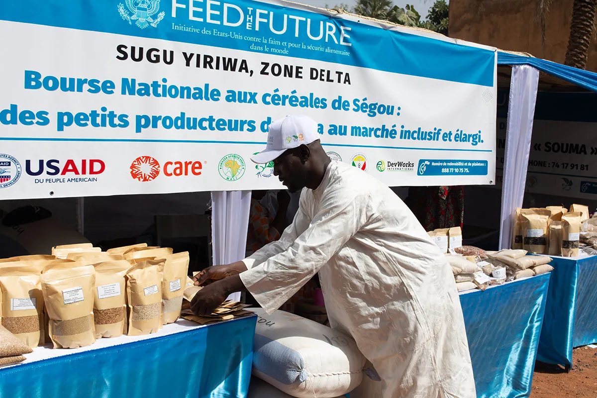 A man arranges goods at a booth with a 